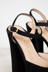 Black ankle strap close up sandal with 'Stuart Weitzman' branding on a light background