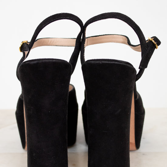 Black suede high-heeled shoes on a white background