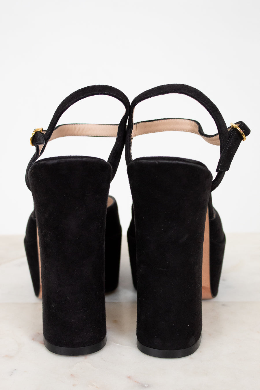 Black suede high-heeled shoes on a white background