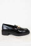 Black loafer shoe with a gold buckle on a white background