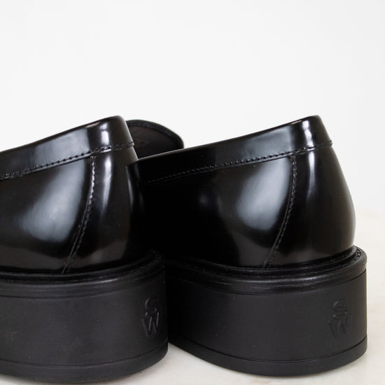 Pair of black platform shoes on a light background