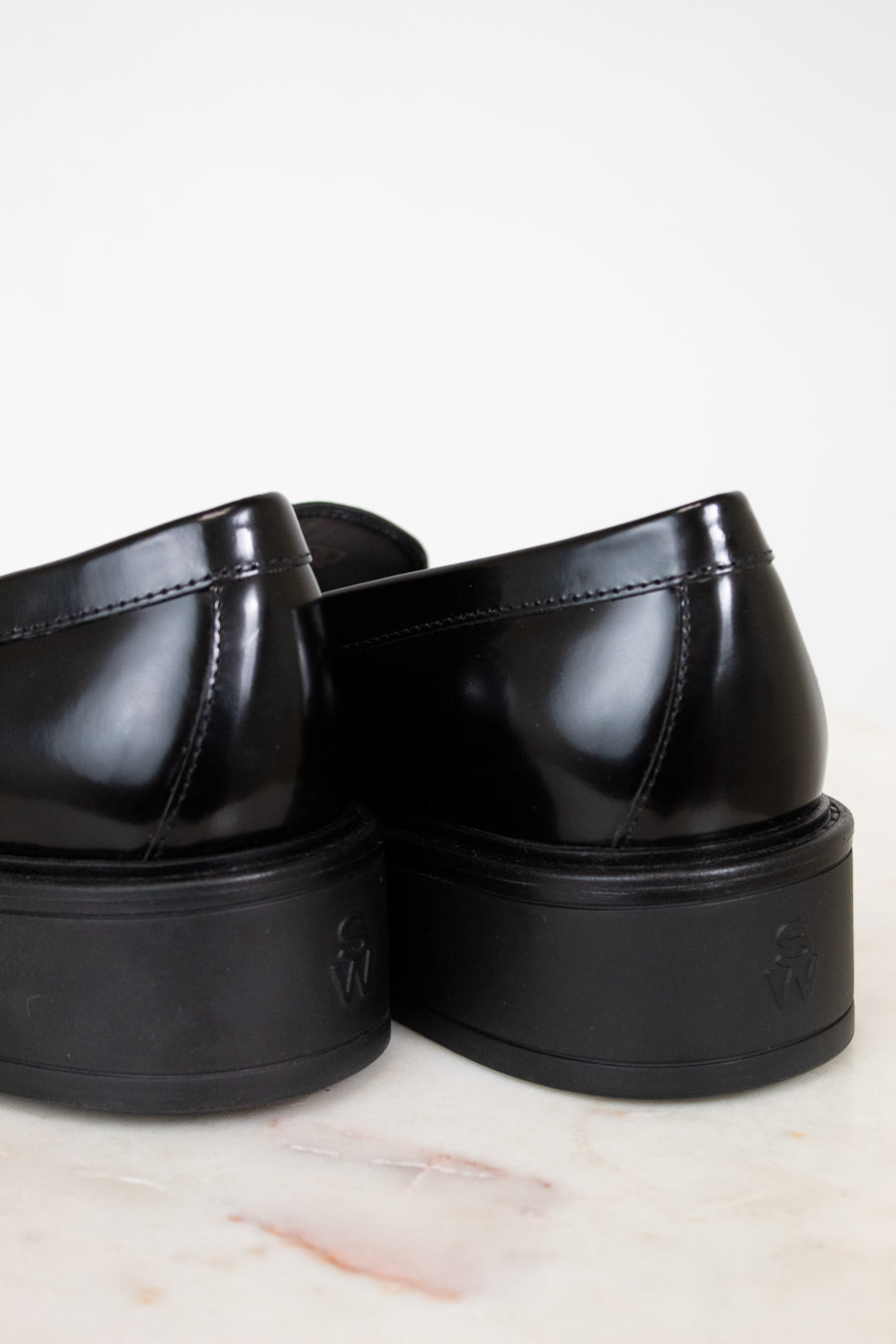 Pair of black platform shoes on a light background