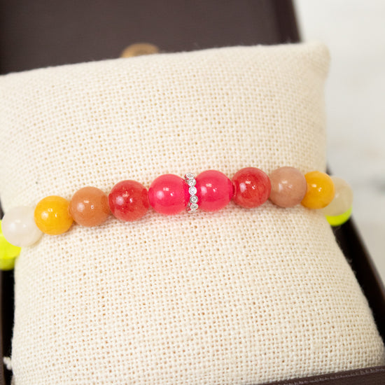 Colorful beaded bracelet on a white fabric surface
