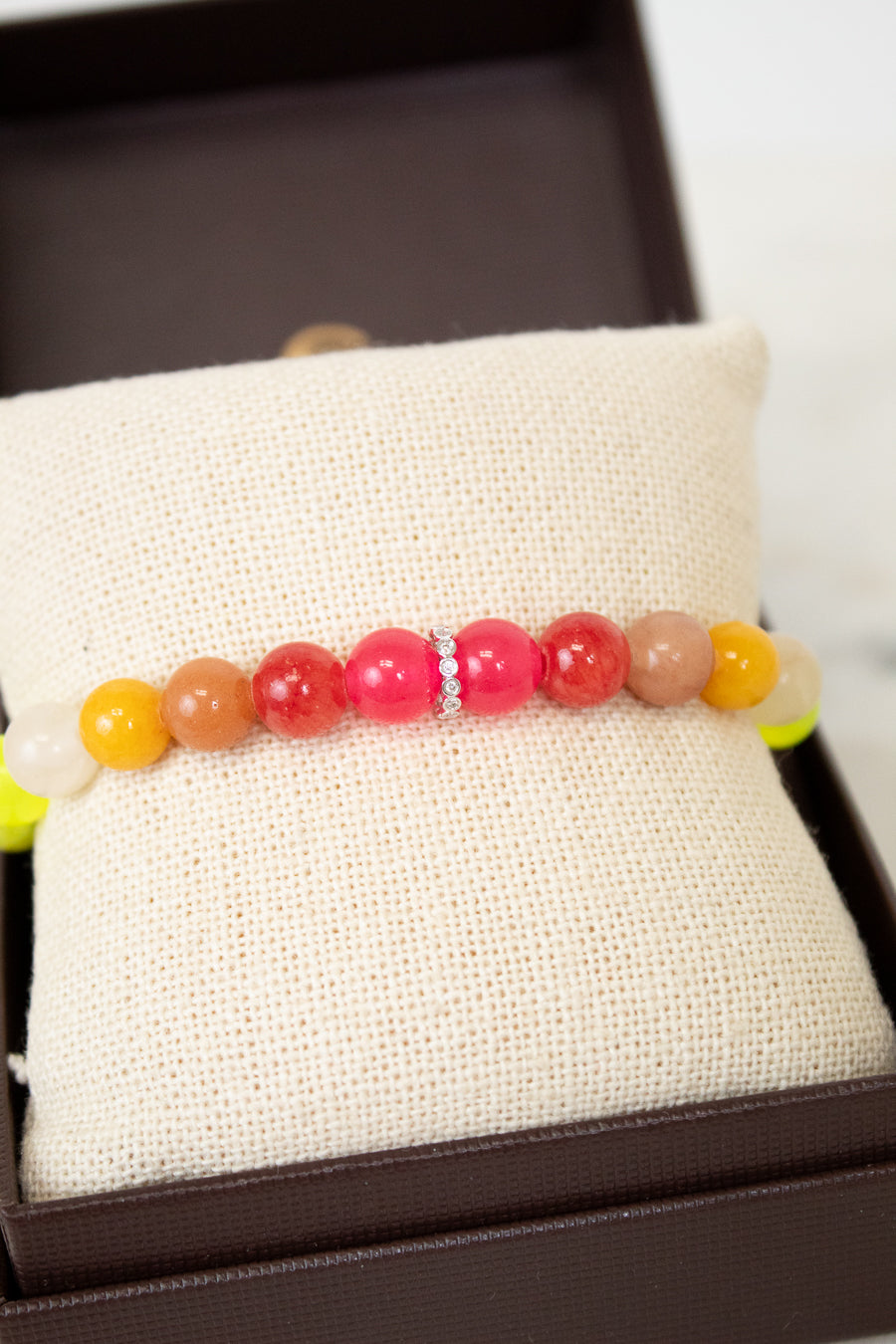 Colorful beaded bracelet on a white fabric surface