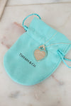 Tiffany & Co. necklace with heart tag on a turquoise pouch on a marble surface