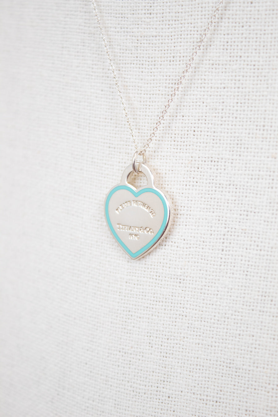 Heart-shaped pendant against white textured background