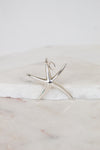 Silver starfish pendant on a marble surface