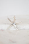 Silver starfish pendant on a marble surface