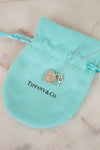Tiffany & Co. necklace with heart and key charms on a turquoise pouch.