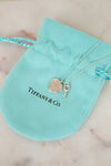 Tiffany & Co. necklace with heart and key charms on a turquoise pouch.