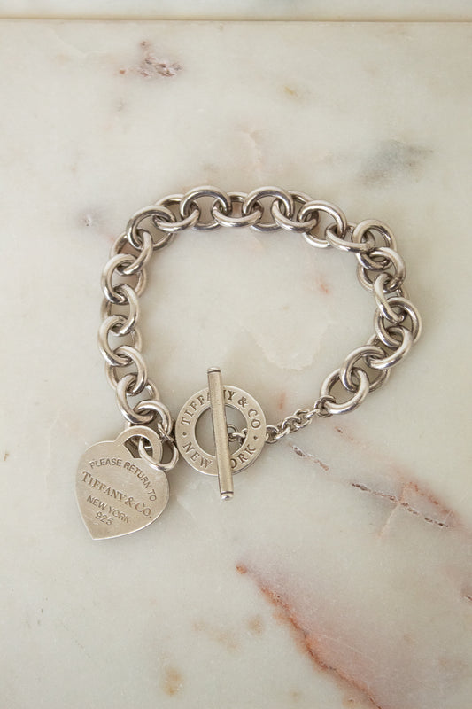 Silver Tone Tiffany & Co heart charm bracelet with chunky interlocking links and toggle clasp.