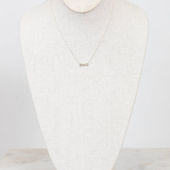 Infinity symbol necklace on white mannequin bust
