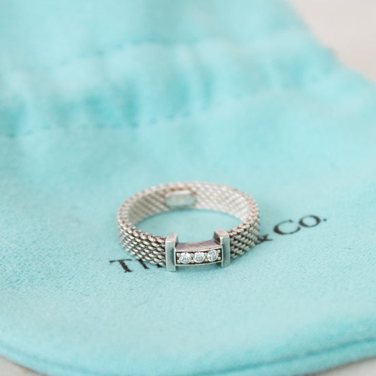 Silver ring with diamonds on a Tiffany & Co. branded pouch