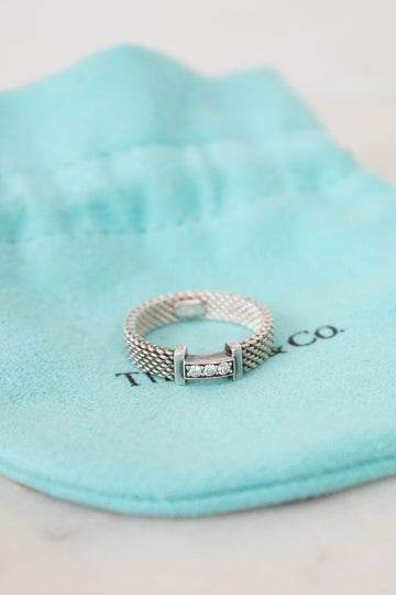 Silver ring with diamonds on a Tiffany & Co. branded pouch
