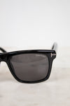 Black Tom Ford sunglasses on a light gray background