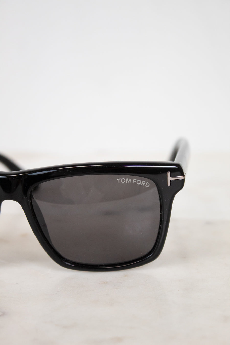 Black Tom Ford sunglasses on a light gray background