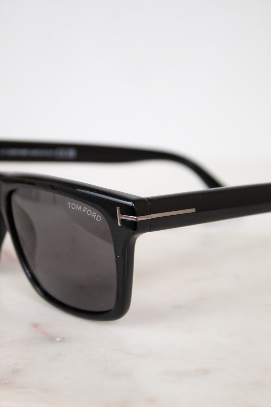Black Tom Ford sunglasses on a light background