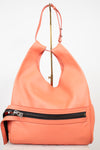 A coral orange leather shoulder bag with a front zippered pocket and a gold-tone metal stand, photographed against a plain white background.