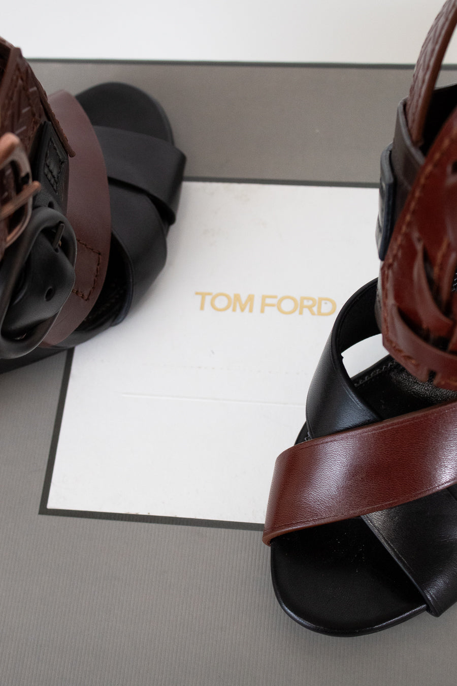 Brown and black sandals on a Tom Ford branded box