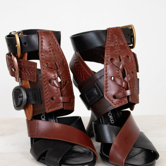 Pair of brown and black leather sandals on a white background
