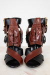 Pair of black and brown leather ankle supports on a white background