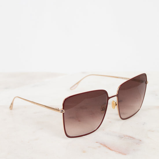 Sunglasses with gold frame and brown lenses on a white background