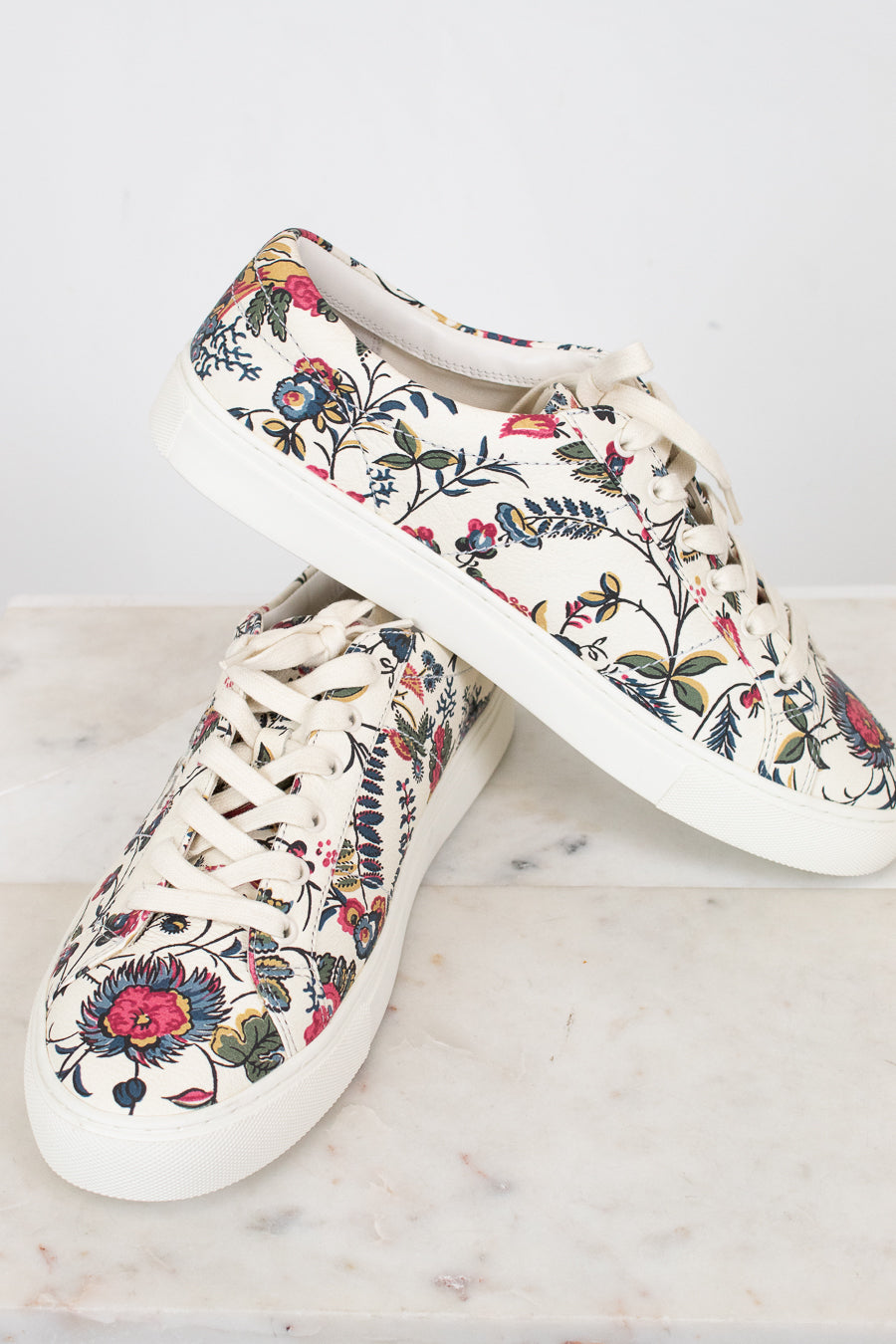 Pair of floral-patterned sneakers on a light background