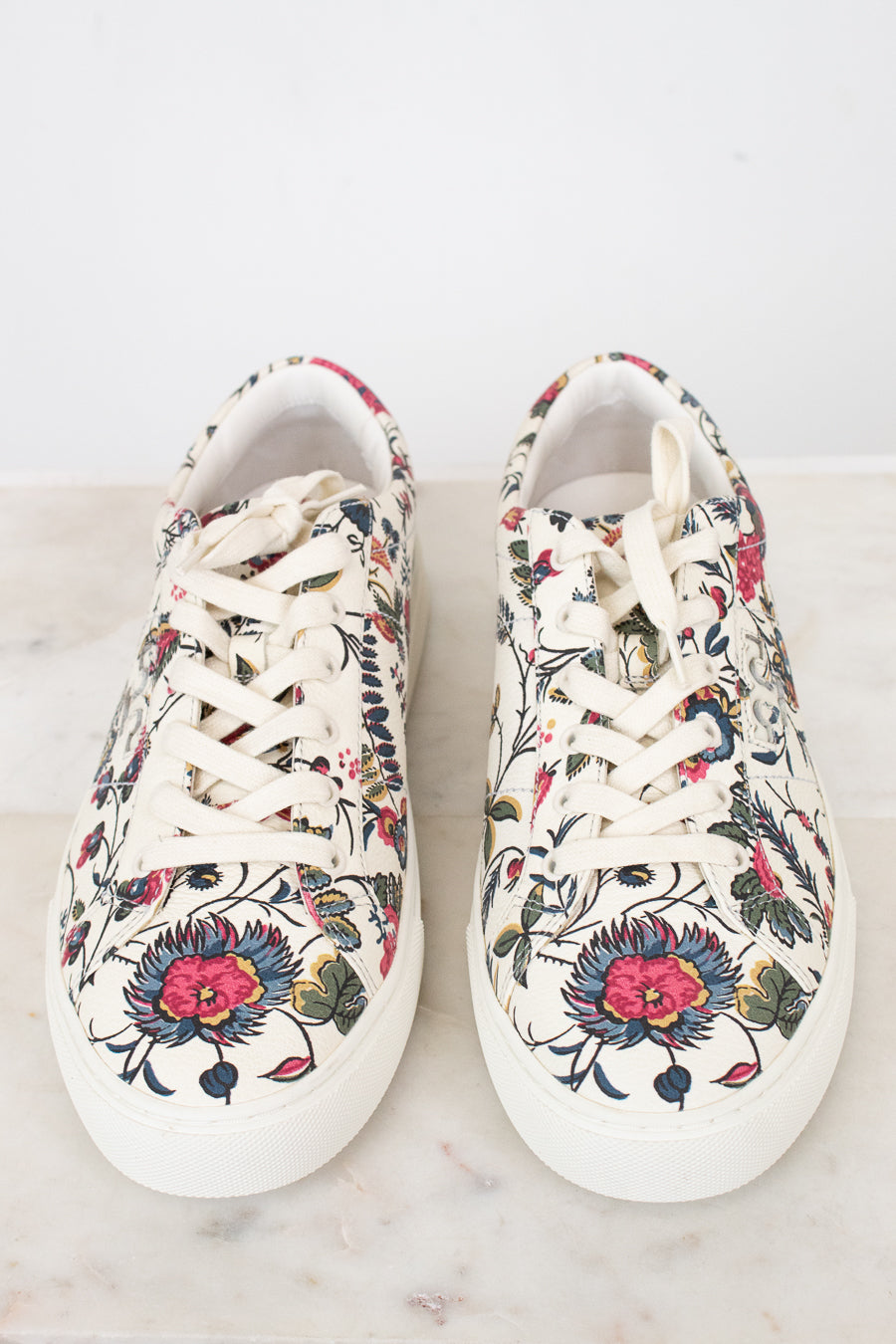 Pair of floral-patterned sneakers on a light background