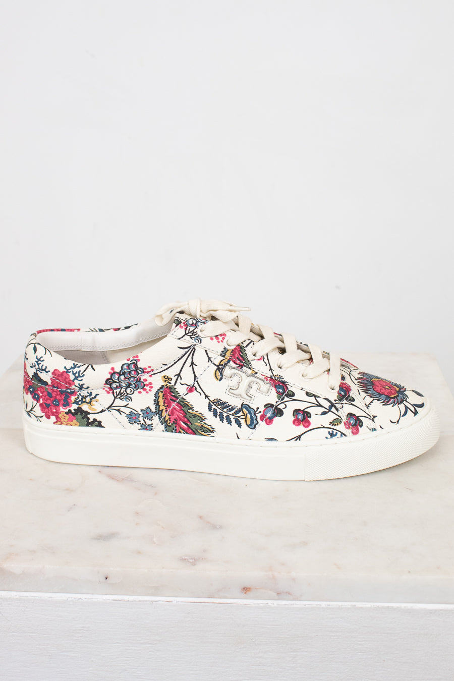 Floral-patterned sneaker on a white marble surface