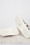 White sneakers with floral pattern on a light gray background