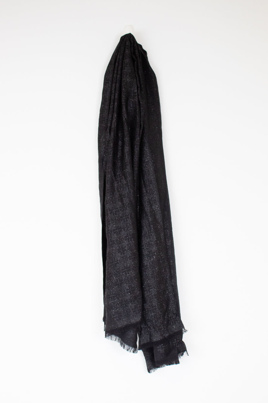 A black textured scarf with fringed edges, draped vertically against a plain white background.