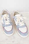 A pair of low-top sneakers in light blue suede and white leather, featuring white laces, a white heart-shaped toe overlay, and thin red piping details, displayed on a white marble surface.