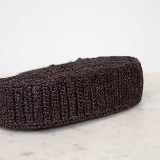 Brown woven purse on a marble and light gray background