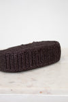 Brown woven purse on a marble and light gray background