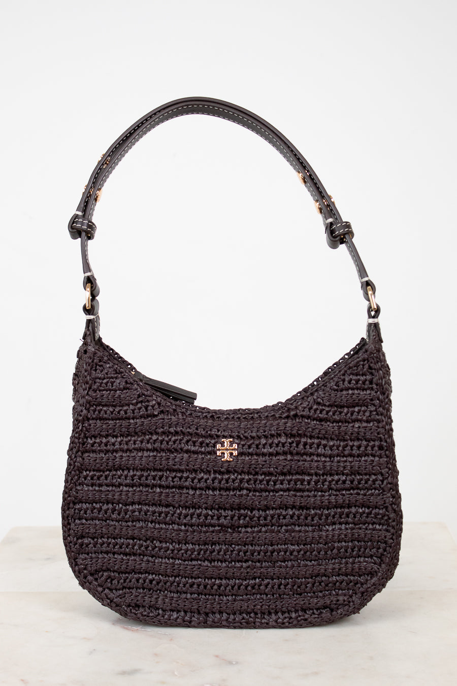 Brown woven handbag with a Tory Burch logo on a white background