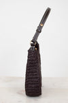 Brown crochet handbag with leather strap on a light gray background