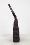 Brown woven purse with brown strap on a light gray background