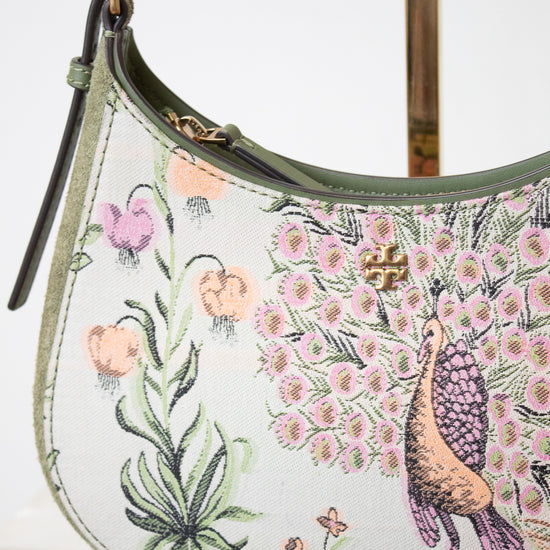 A close up view of the print on the TORY BURCH bag showing colorful peacock and flowers