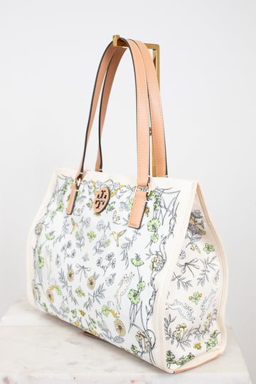 Floral-patterned handbag with beige straps on a white background