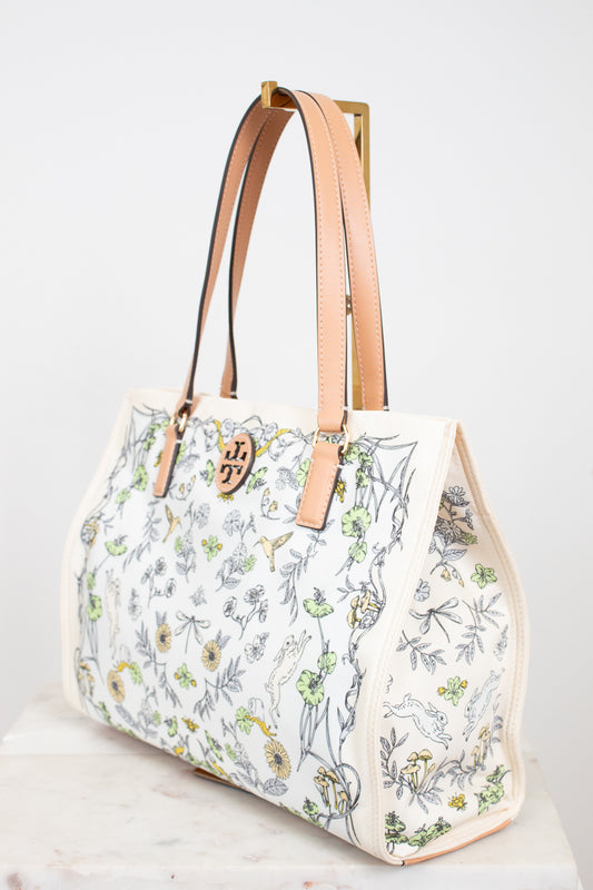 Floral-patterned handbag with beige straps on a white background