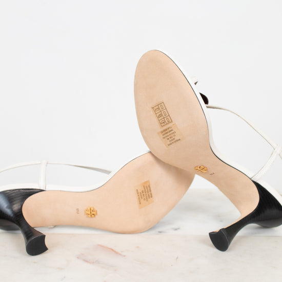Bottom view of high-heeled shoes with beige soles on a white background
