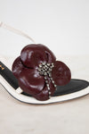 White and maroon leather flower accessory with rhinestones on a white background
