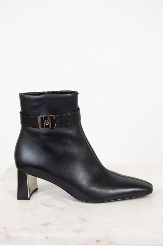 Side view of a black leather ankle boot with strap detail around ankle.