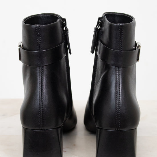 Back view of black leather ankle boots showing block heel and ankle strap detail