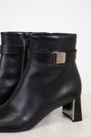 Close-up view of silver buckle detail on strap around ankle