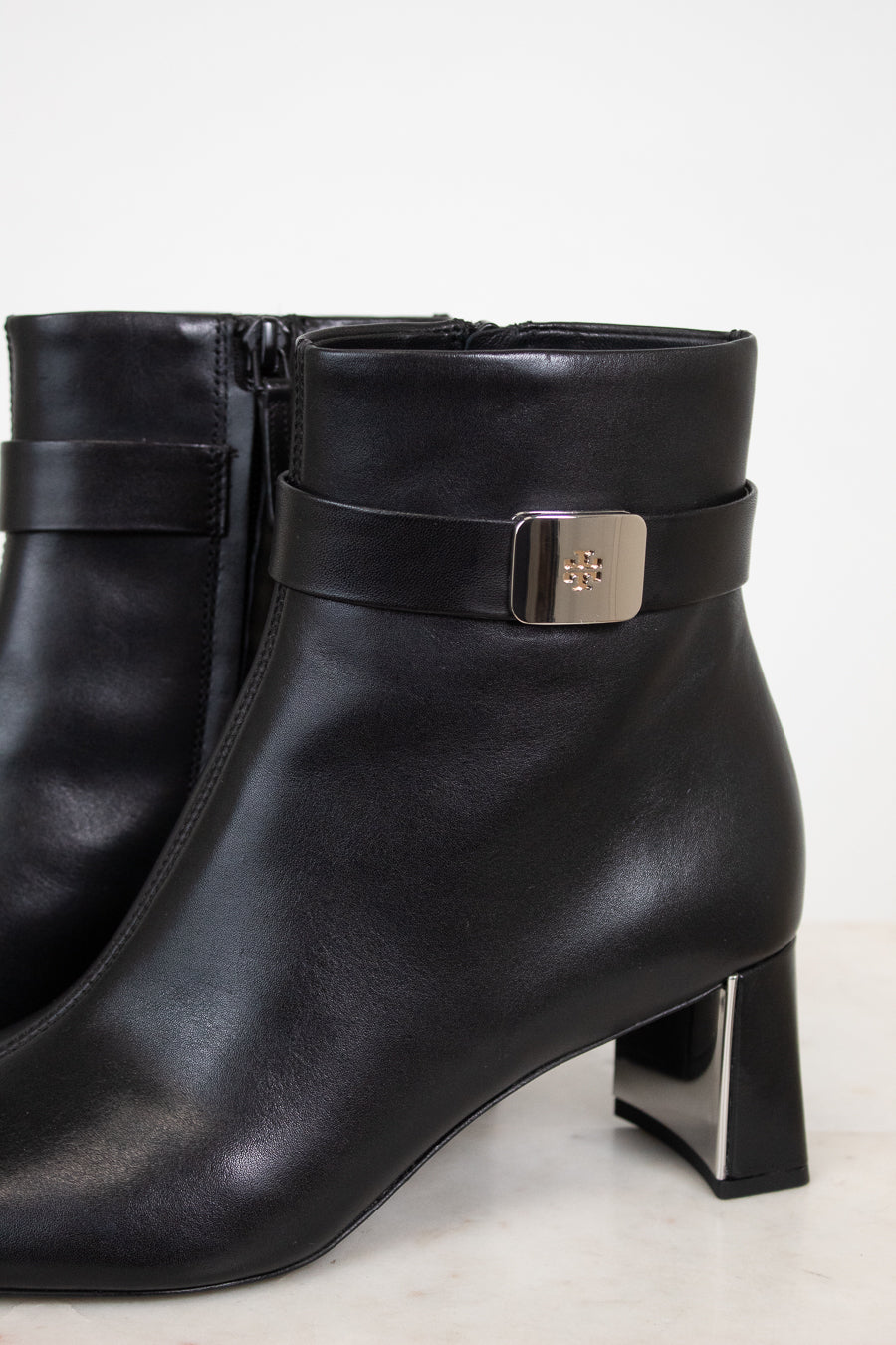 Close-up view of silver buckle detail on strap around ankle