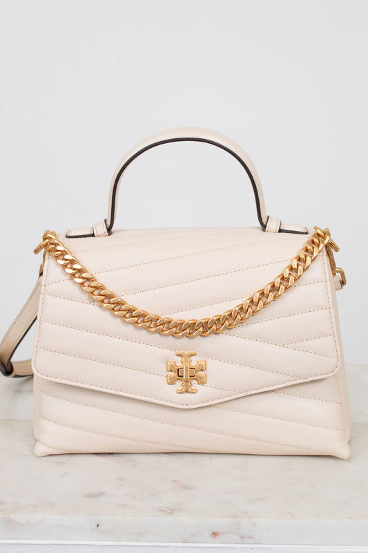 Beige handbag with gold chain detail on a light background