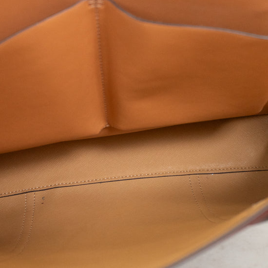 Close-up of the tan leather interior lining of a handbag, showing the smooth material and fine stitching.