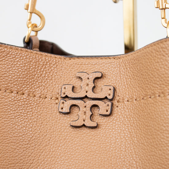Close-up of a brown leather handbag with gold hardware and a visible brand logo.