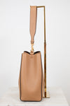 Tan handbag with a strap on a white background
